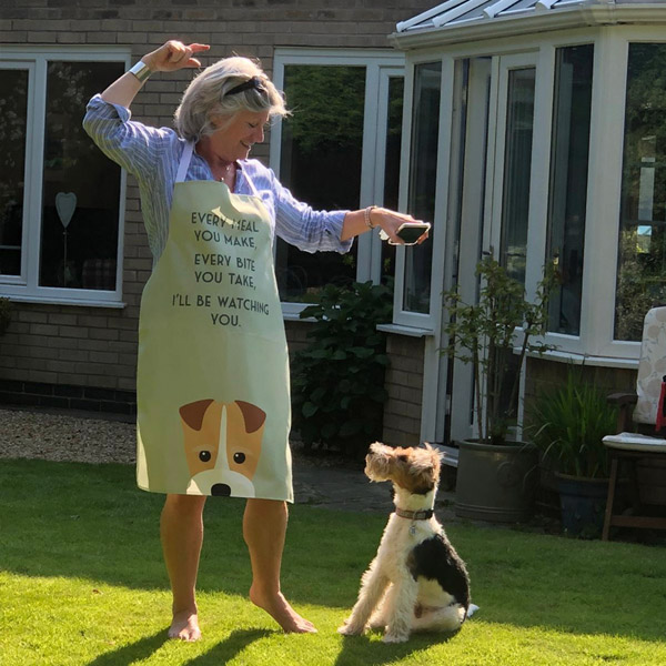 A lady playing with her dog wearing a personalised apron