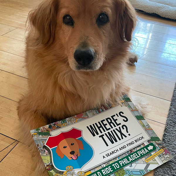 Twix posing proudly with a Personalised Where's Twix Book